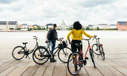 Guide and guest with bicycles in Copenhagen on Foods of Copenhagen tour.